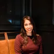 Lacey Villaseñor smiling, seated in a leather booth against dark wood panels